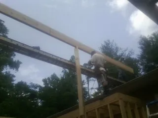 Carpenter setting a ridge beam over a new addition frame — Ice Dam Removal by Roofing Brothers in Keasbey