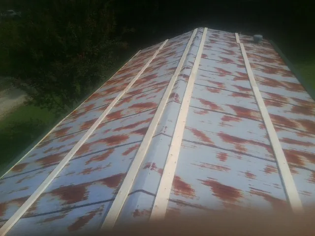 Rusted metal roof panels with new wood purlins before replacement — Storm Damage Roof Repair in Keasbey by Roofing Brothers