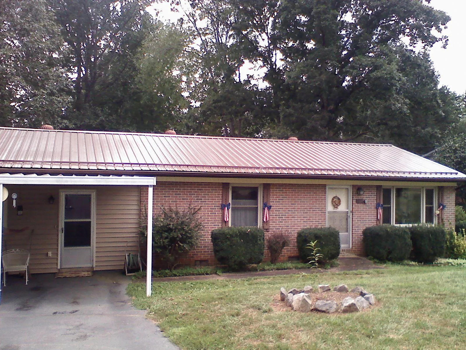 Bronze metal roof and carport on a brick ranch home — Roof Repair work by our crew in Keasbey
